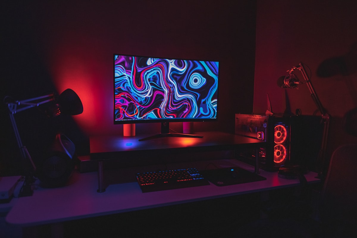 A gaming station with an RGB-lit PC, mechanical keyboard and wide monitor